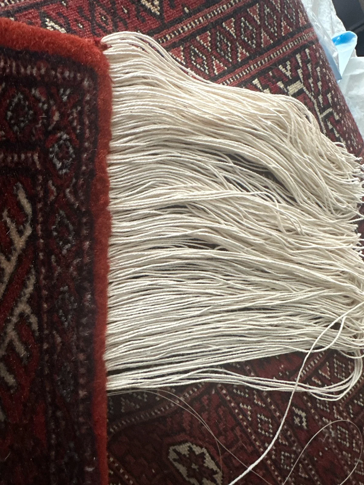 A worn rug edge part-way through overcasting by hand, in for cleaning from Pinecrest